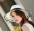 Elegante sombrero de sol de verano para mujer: detalle de lazo negro grande con paja plegable y ala ancha
